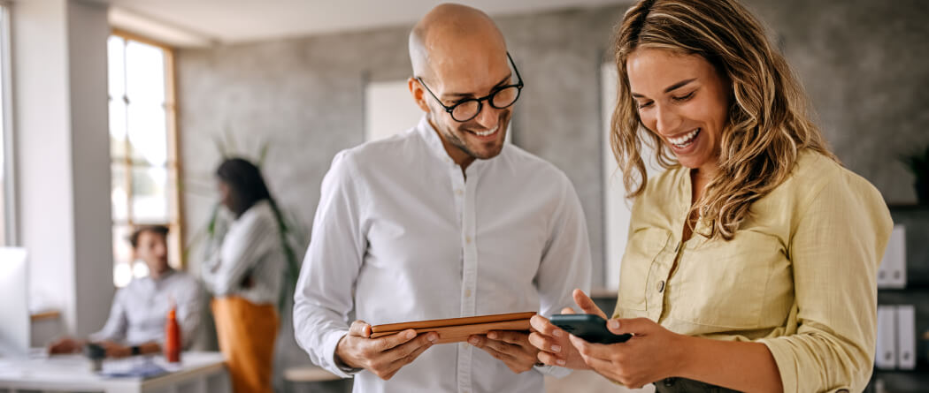 two coworkers viewing their mobile and tablet devices