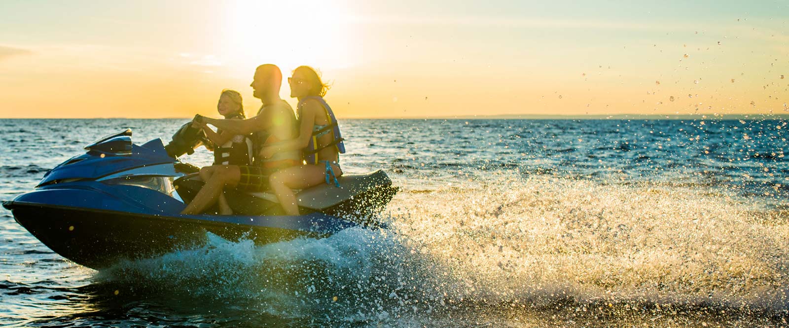 Family riding a jet ski on the lake.