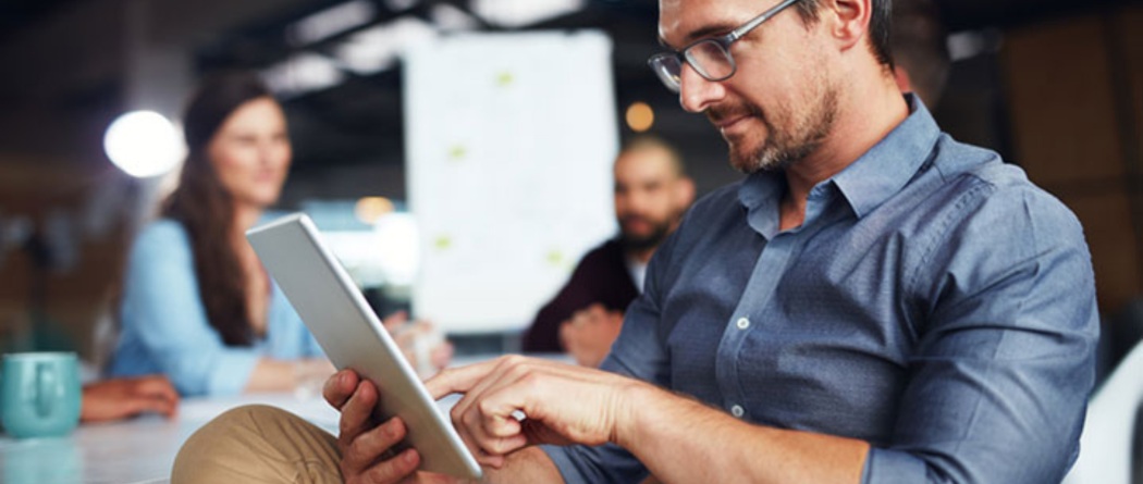 Person sitting in meeting using a tablet.